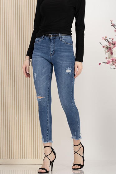Kék skinny farmer kisebb hasításokkal az anyagban szintetikus bőr övvel